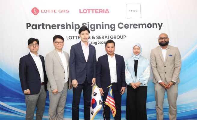 Shin Yoo-yeol (3rd from L), executive vice president of the Future Strategy Office at Lotte Corp., and Serai Group Chairman Najib Hamid (4th from L) pose for photos with other officials after signing a partnership agreement for the launch of Lotte GRS' Lotteria burger chain in Malaysia at the Lotte World Tower in Jamsil, southeastern Seoul, on Aug. 6, 2025, in this photo provided by Lotte GRS. (Yonhap)
