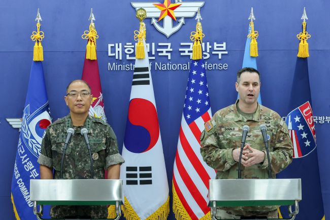 Joint Chiefs of Staff spokesperson Col. Lee Sung-jun (L) and Col. Ryan Donald, spokesperson for the U.S. Forces Korea, pose for a photo during their press briefing at the defense ministry in Seoul on Aug. 7, 2025. (Image courtesy of Yonhap)