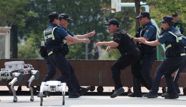 On the afternoon of May 28, at Suseong Lake in Suseong District, Daegu, during a digital joint patrol demonstration by the Daegu Metropolitan Police Agency using AI drones and robots, two “Polibot” patrol robots pursued and confronted a sexual assault suspect while the mobile patrol unit arrived to subdue him. (Yonhap)