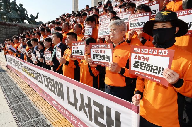 Officials from the National Firefighters’ Chapter of the Korean Government Employees’ Union hold a press conference on November 5 on the steps of the main National Assembly building in Yeouido, Seoul, urging President Lee Jae Myung to engage in dialogue with frontline firefighters. Since April 1, 2020, all firefighters in Korea have been classified as national civil servants and fall under the category of special-service public officials. (Yonhap)
