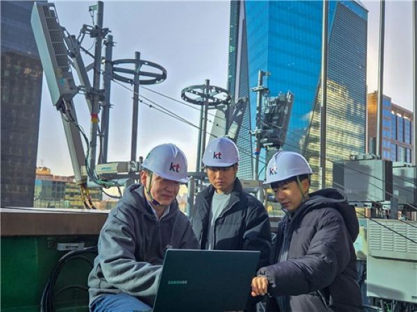 This undated photo provided by KT Corp. shows officials from Samsung Electronics Co. and KT Corp. evaluating the results of AI-RAN optimization technology. (Yonhap)