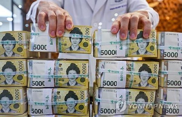 An official inspects 50,000 won banknotes at Hana Bank's counterfeit response center in Seoul, in this file photo taken July 17, 2024. (Yonhap)