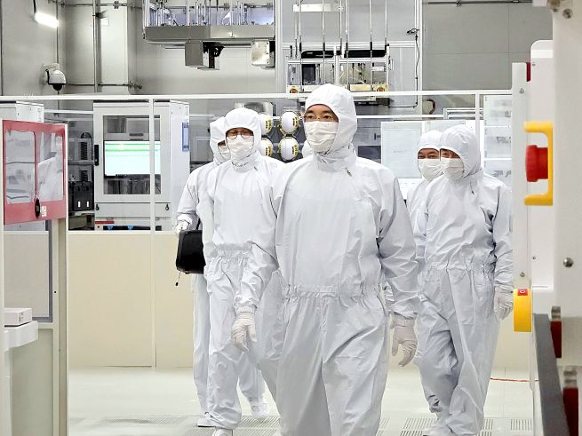 Samsung Electronics Chairman Lee Jae-yong (front) examines the semiconductor research and development complex of the company, located in Giheung, south of Seoul, in this photo provided by the company on Dec. 22, 2025. (Yonhap)