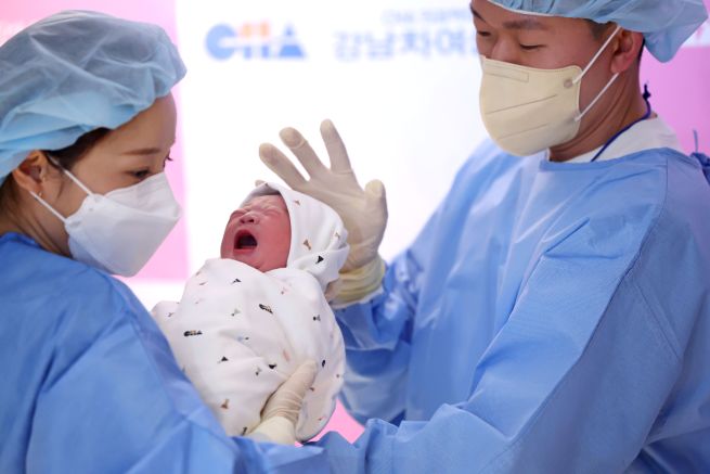 On Jan. 1, the first day of the New Year 2026, the Year of the Byeong-o (Fire Horse), Yoon Sung-min (right) holds Jjaem-i — the baby girl’s prenatal nickname — who was born to him and his wife, Hwang Eun-jung, at Gangnam CHA Women’s Hospital in Seoul. (Yonhap)
