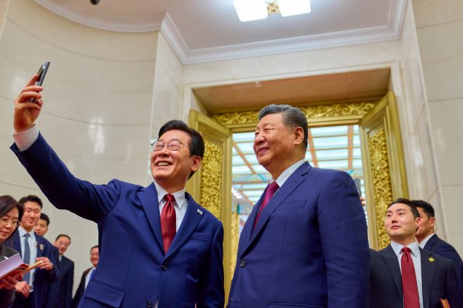 South Korean President Lee Jae Myung (L) takes a selfie with Chinese President Xi Jinping by using a Xiaomi smartphone following a state dinner for the South Korean leader in Beijing on Jan. 5, 2026. The smartphone was gifted to Lee by Xi during their first summit talks in Gyeongju, South Korea, in November 2025. (Pool photo) (Yonhap)