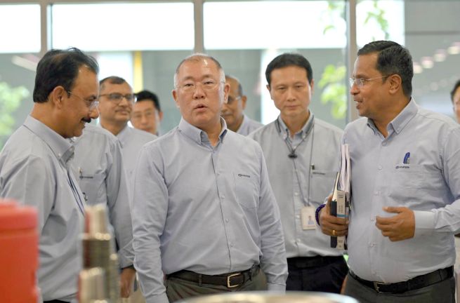 This photo, provided by Hyundai Motor Group on Jan. 14, 2026, shows its Executive Chair Euisun Chung (3rd from R) talking with officials from the company's production facilities in India. (Yonhap)