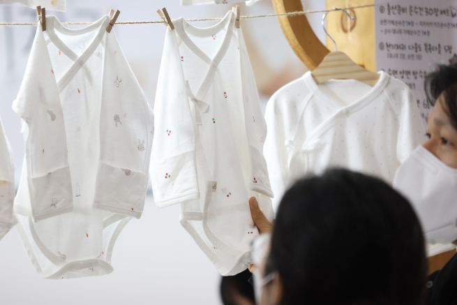 Expectant parents browse baby clothes at the “2026 Moms Holic Baby Fair,” held on Jan. 15 at COEX in Gangnam District, Seoul. (Yonhap)